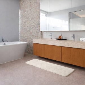 "Off-white bath mat runner in front of floating vanity in luxury spa bathroom with freestanding tub, floor-to-ceiling windows, and wood flooring"