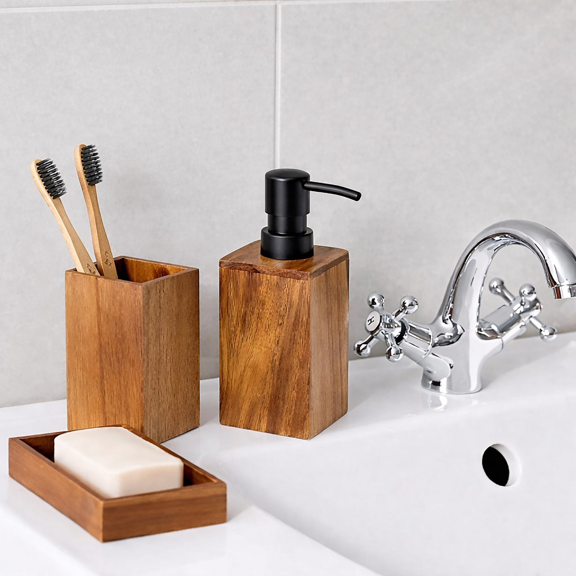 Soap dispenser tumbler toothbrush holder on sink with chrome faucet