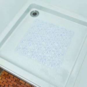 Clear bubble-pattern shower mat placed in white shower base with orange tile surround