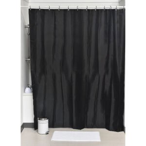 Black shower curtain hanging in bathroom with white mat and trash bin