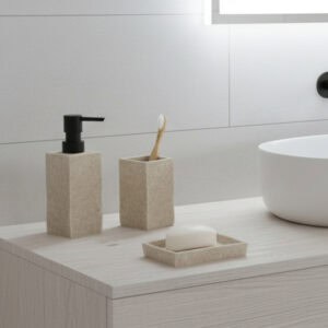 Natural stone effect soap dispenser with dark pump displayed near sink and towels