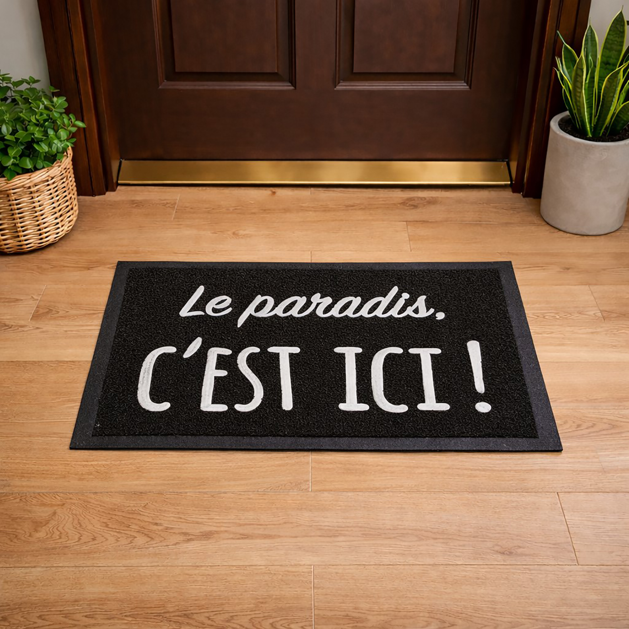 Lifestyle view of black Le paradis, c'est ici! door mat placed in front of wooden entry door