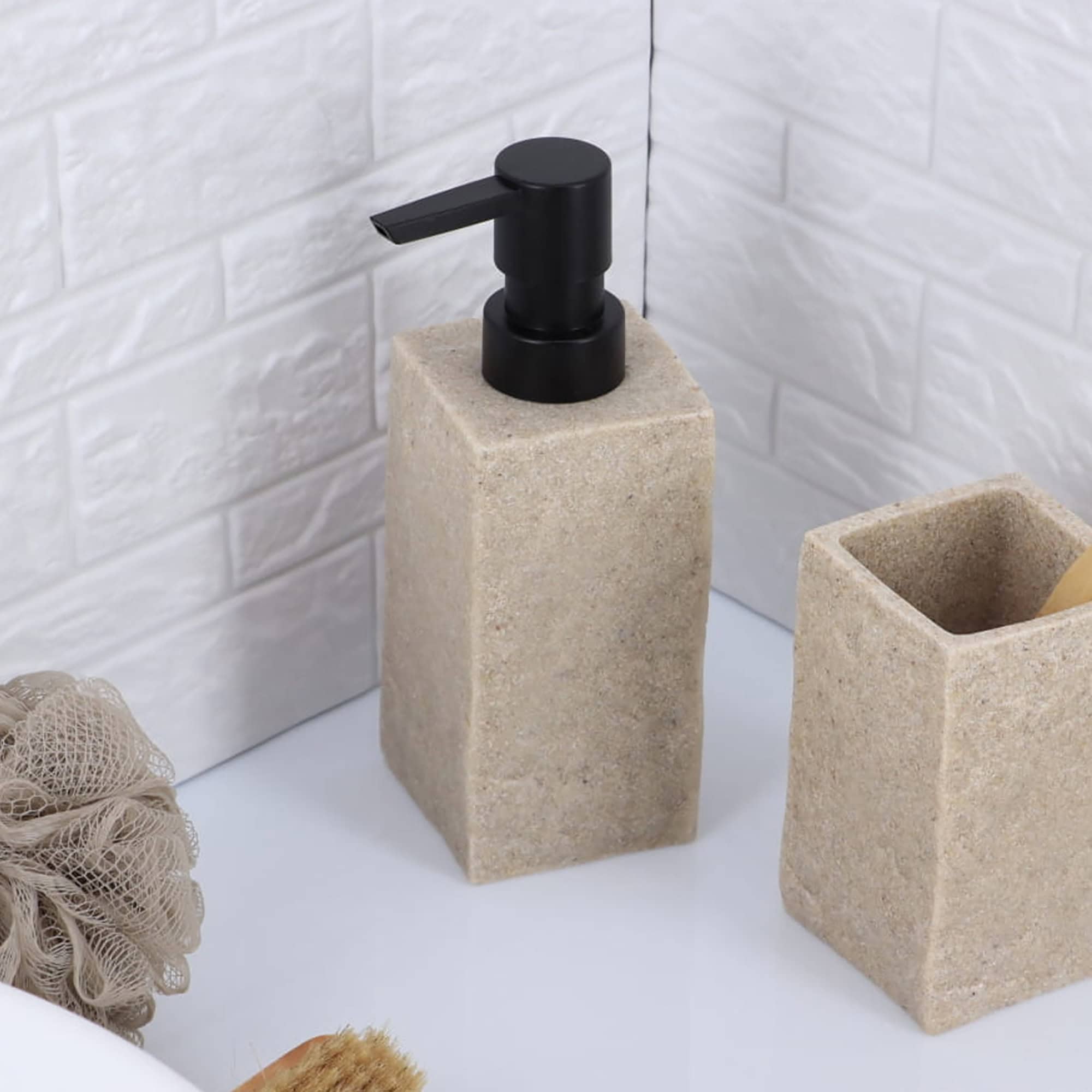 A natural stone-effect soap dispenser with a black pump, displayed next to a matching toothbrush holder on a bathroom countertop.