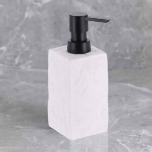 A white stone-effect soap dispenser with a black pump, set against a textured marble background for a modern aesthetic.