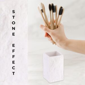 A white stone-effect bathroom tumbler holding two bamboo toothbrushes, displayed against a neutral background for a clean and natural look.