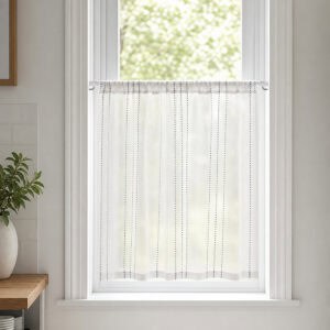 White cafe rod holding a sheer striped tier curtain across a bright kitchen window, styled with a green plant and light neutral decor for a farmhouse look.