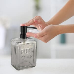Hand Pump Operation on Smoke Gray Glass Soap Dispenser for Convenient Use – A person pressing down the black pump on the smoke gray glass soap dispenser, illustrating smooth hand-pump functionality.