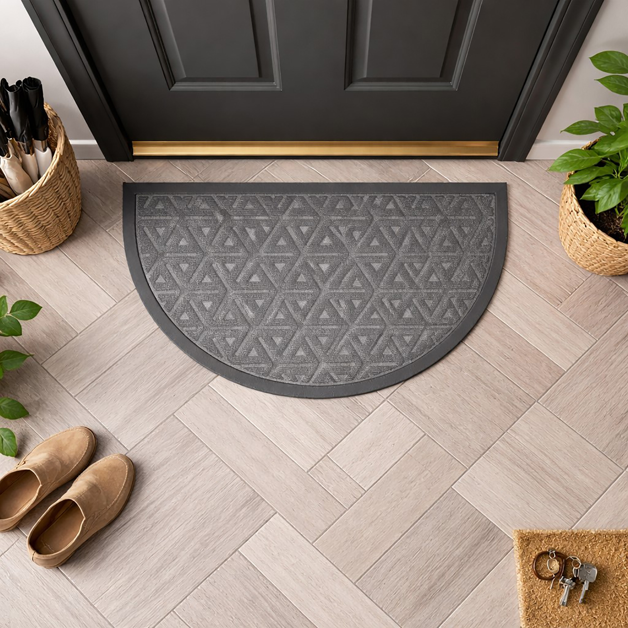 Top view of gray half round door mat in front of dark door
