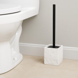 White stone effect toilet brush holder with black handle beside white toilet