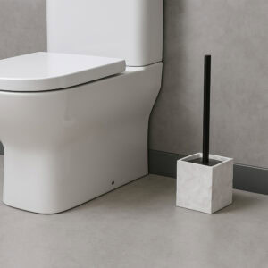 Stone effect toilet brush holder in square white base next to white toilet