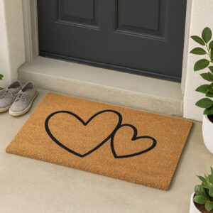 Natural coir doormat with two black hearts placed at dark entry door
