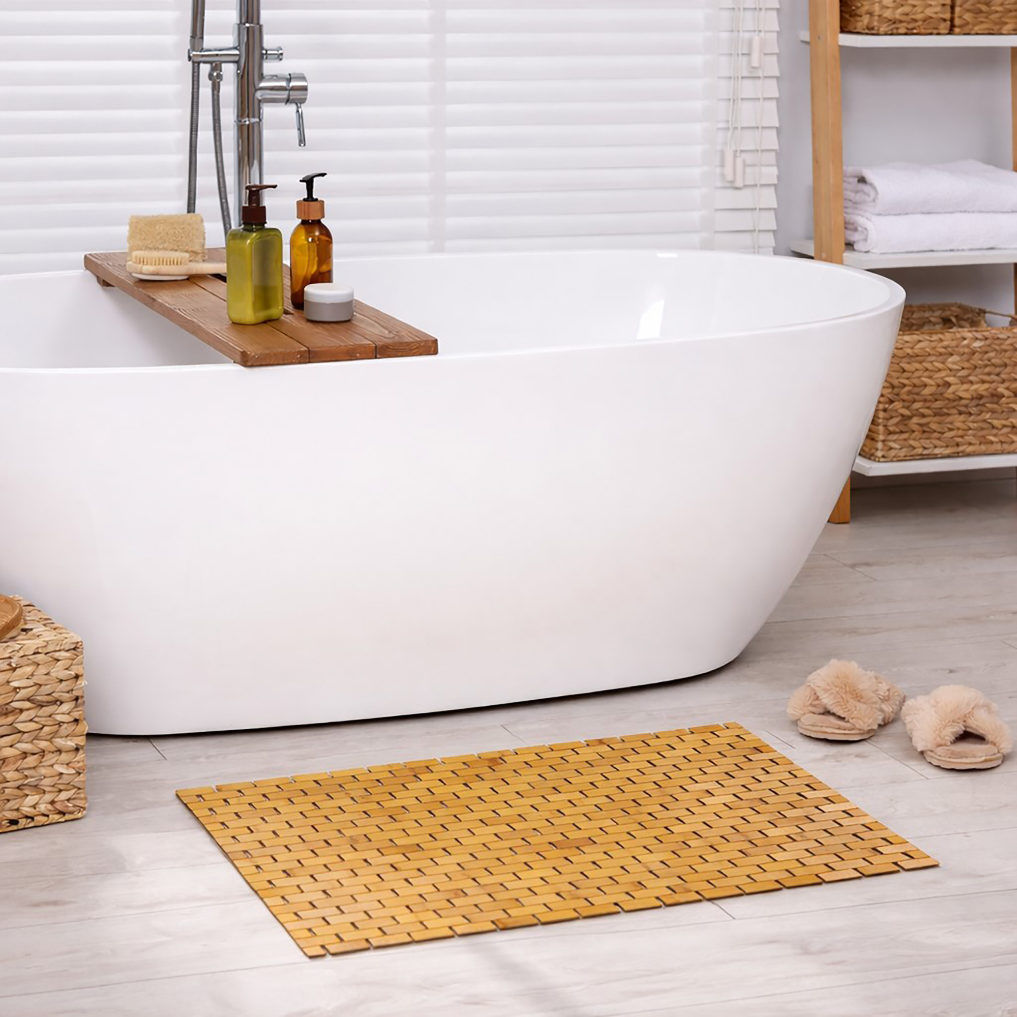 Bamboo bath mat on bathroom floor, in front of a bathtub