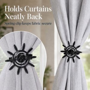 5- Close up of a black silver sun tieback holding a gray curtain neatly back, highlighting the secure spring clip mechanism.