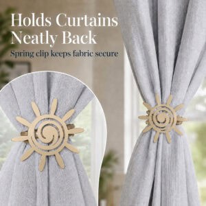 5- Close up of a matte gold sun tieback holding a gray curtain neatly back, highlighting the secure spring clip mechanism.