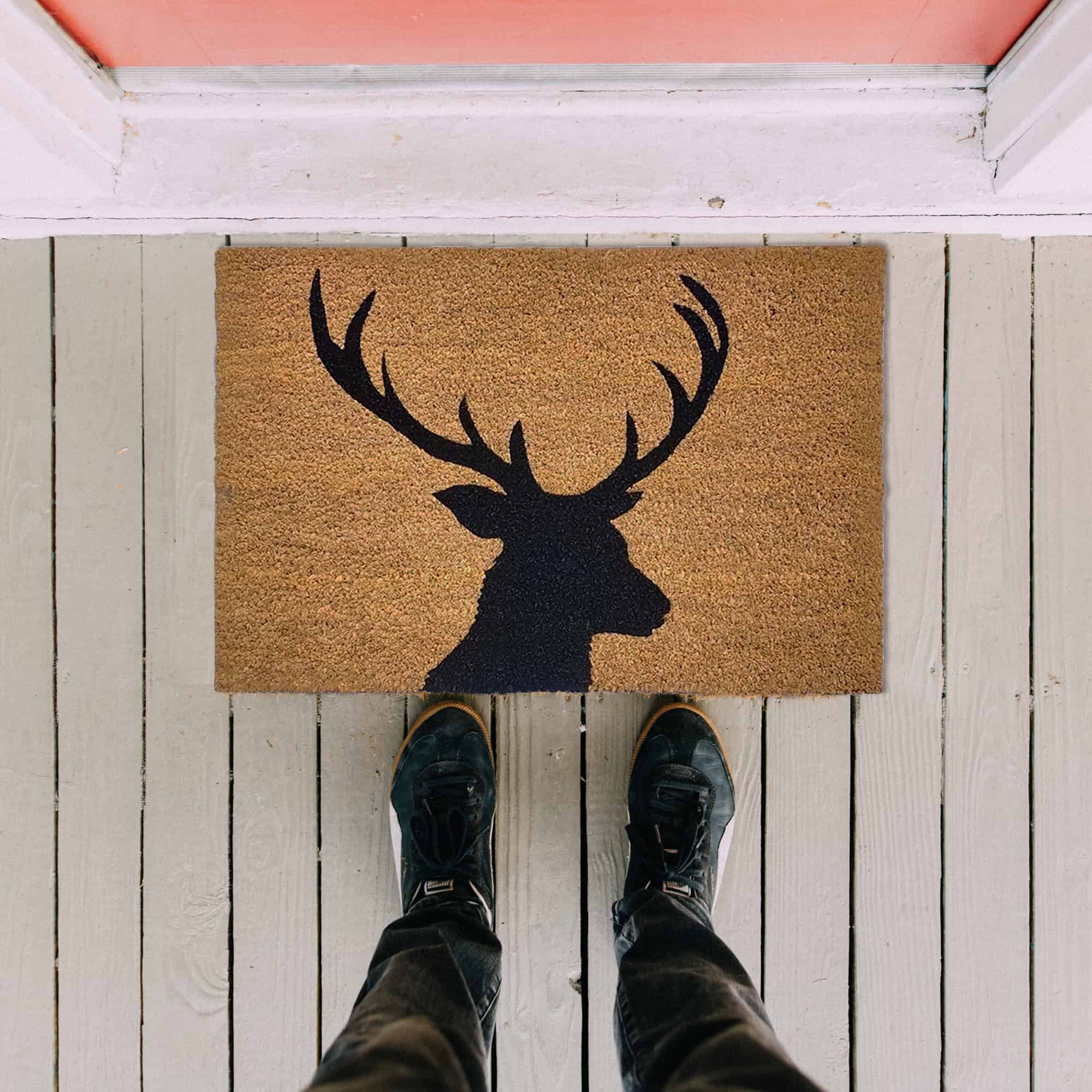 reindeer door mat in situation on the floor with man legs and feet