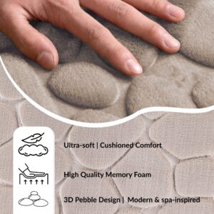 Hand pressing into a cushioned taupe pebble mat illustrating softness, memory foam filling, and spa-inspired comfort