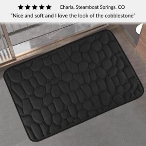 Black memory foam mat with raised pebble design placed outside shower door with five-star customer review text overlay