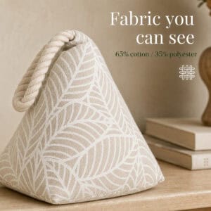 White leaf print cone door stopper on a wood surface beside books, with a weave icon. On-image text: "Fabric you can see," "65% cotton / 35% polyester."