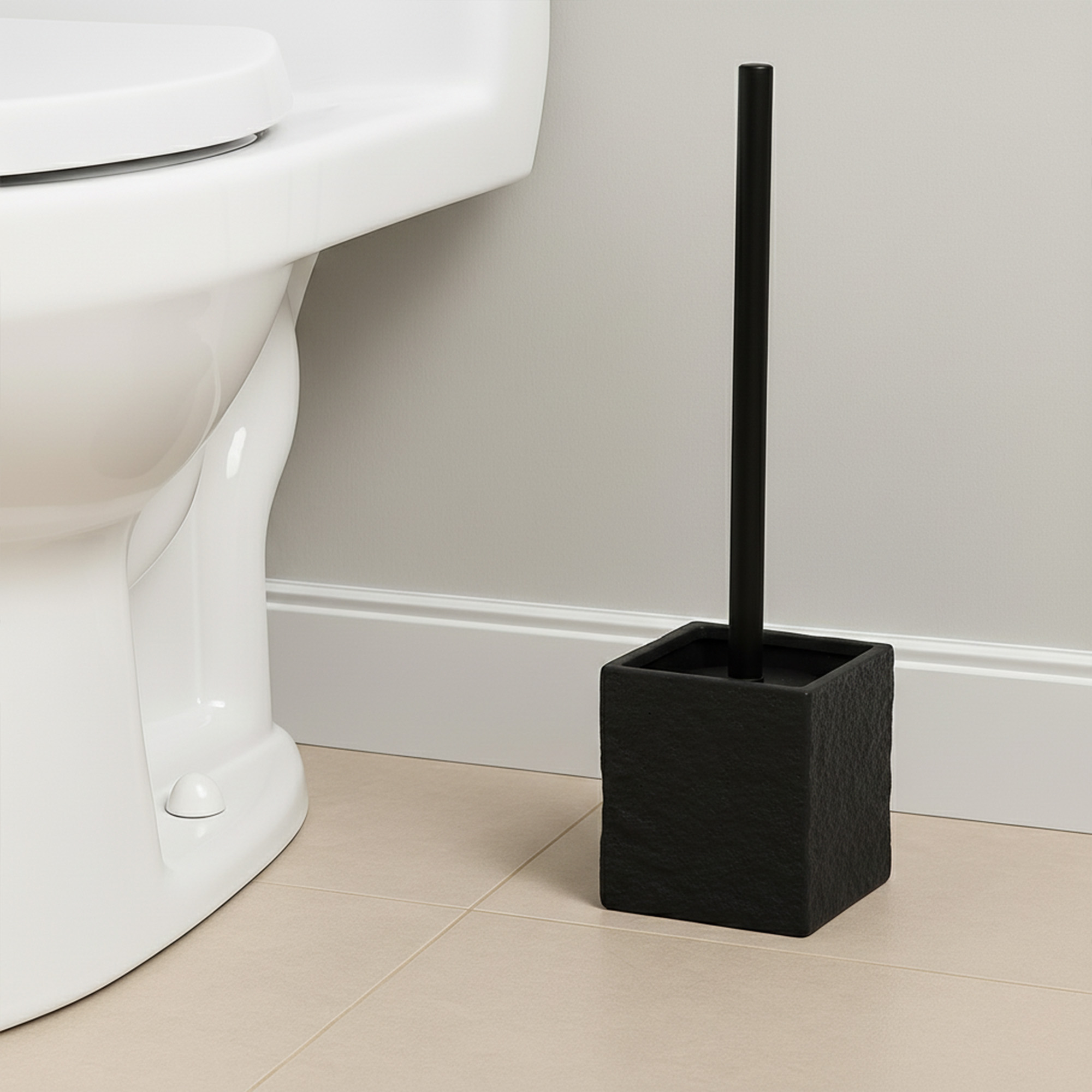 Black stone effect toilet brush holder beside white toilet