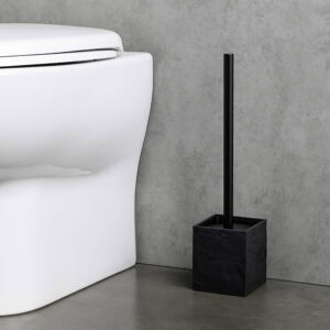 Black stone effect toilet brush holder next to white toilet on gray floor