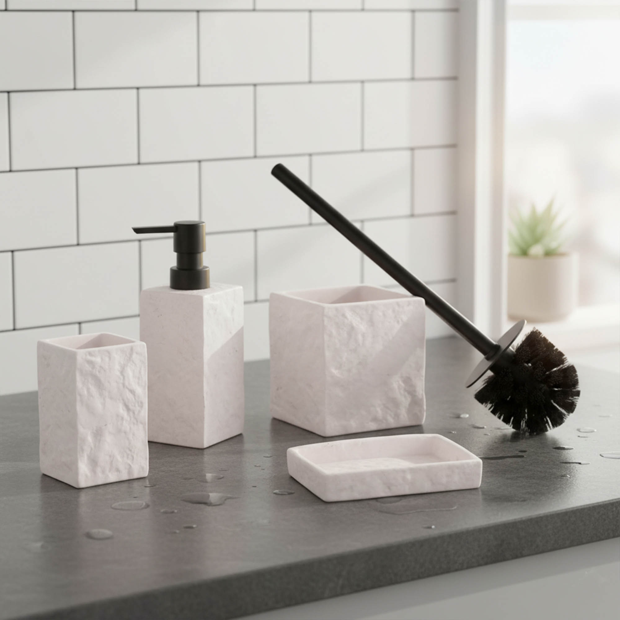 White stone-effect 4-piece bathroom accessory set with black pump and brush on countertop