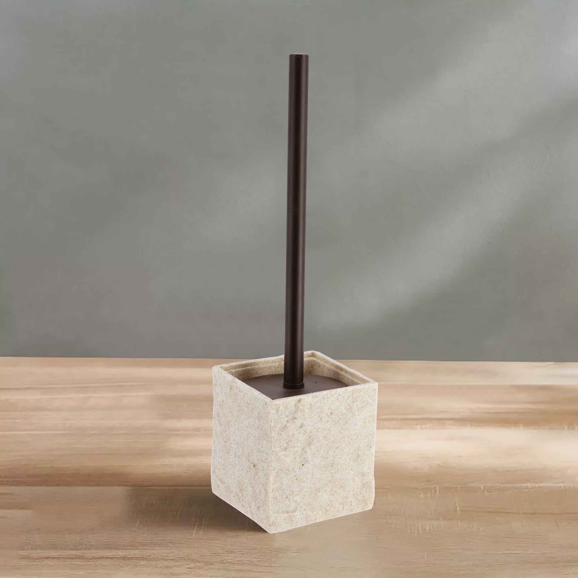 A natural stone-effect toilet brush holder with a black handle, displayed on a wooden surface against a soft green wall for a clean aesthetic.