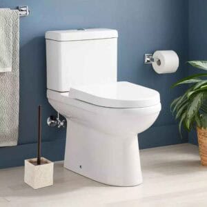 Natural stone effect toilet brush holder beside white toilet in blue bathroom