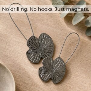 Flat-lay bois: Set of 2 polished graphite water lily magnetic curtain tiebacks on light wood, no drilling no hooks just magnets