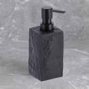 A black stone-effect soap dispenser with a black pump, set against a textured marble background for a modern aesthetic.