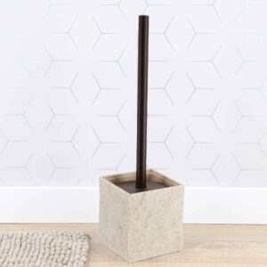 Beige stone effect toilet brush holder against white hexagonal tile wall