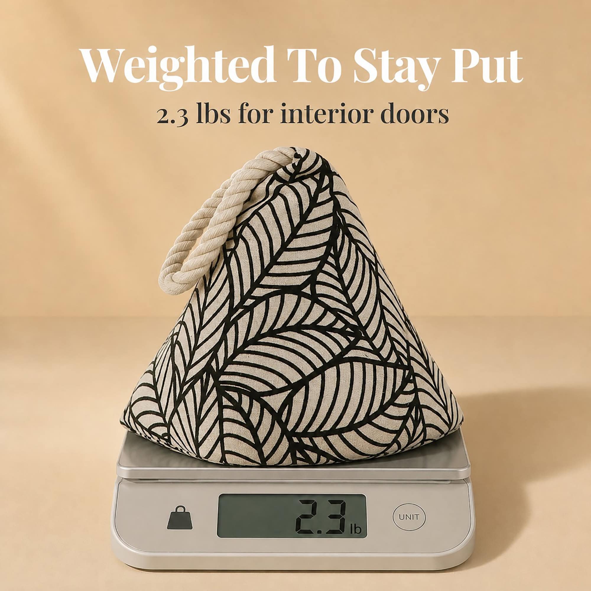 Black leaf print cone door stopper on a digital scale reading 2.3 lb. On-image text: "Weighted To Stay Put," "2.3 lbs for interior doors."