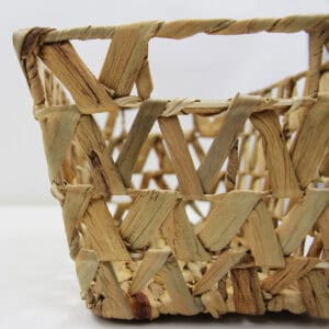 Close-up detail of the open lattice weave pattern on a natural water hyacinth basket.