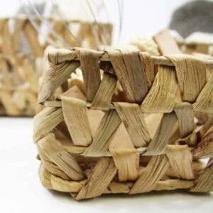 Close-up detail of the open lattice weave pattern on a natural water hyacinth rectangular basket filled with bath items.