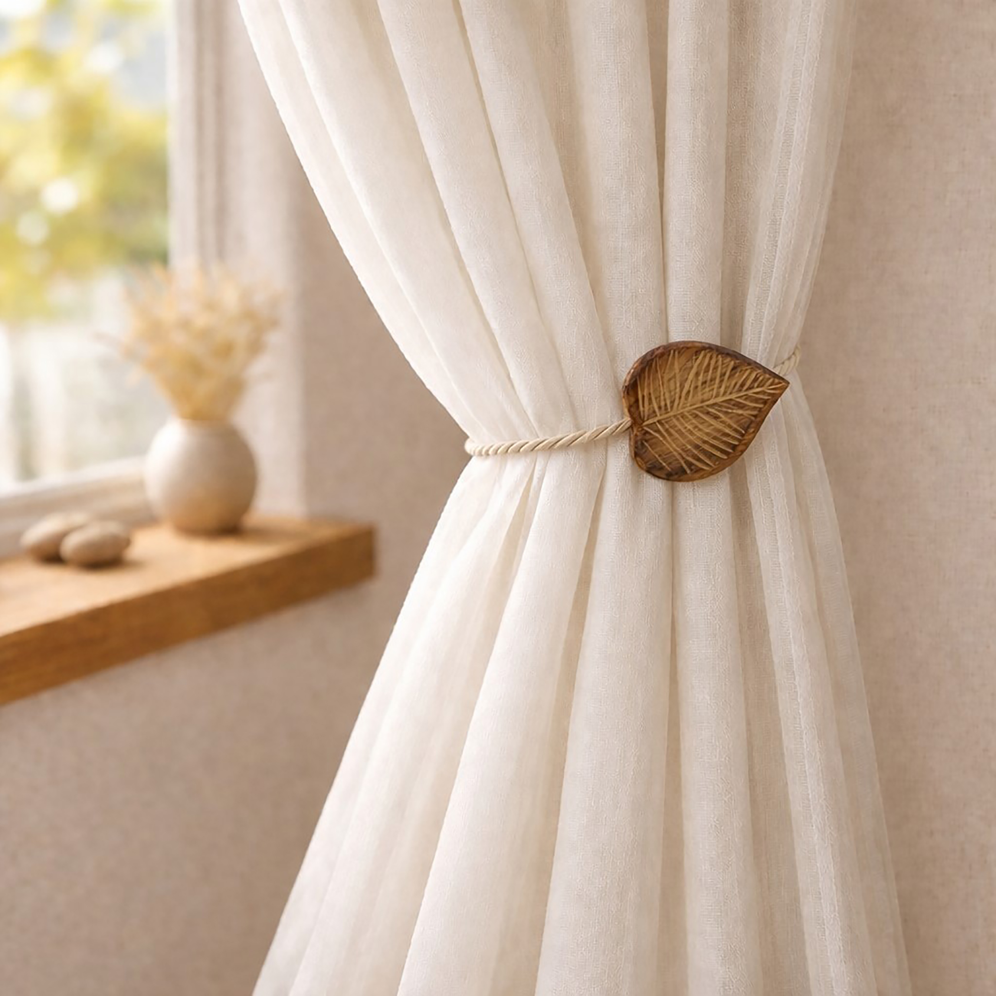 Natural wood leaf tieback holding sheer curtain by sunny window