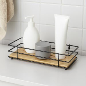 "Black wire bamboo tray holding soap dispenser, cream jar, and lotion tube on bathroom counter"
