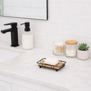 "Black wire soap dish on white bathroom vanity with black faucet"