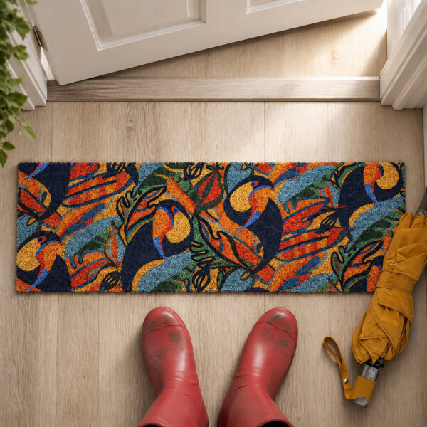 Top view of toucans coir entryway mat at an open front door next to red rain boots and a yellow umbrella