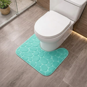 Aqua blue memory foam contour bath mat with pebble texture positioned around toilet base, angled view