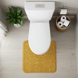 Top-down view of mustard yellow pebble-texture contour mat fitted around toilet base