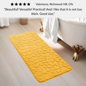 Mustard yellow memory foam runner mat placed beside bathtub in spa-style bathroom with customer review highlighting versatility and size