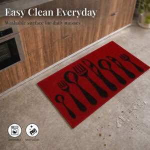 Red kitchen mat on a tiled floor beside scattered crumbs and a water spill, showing the washable easy clean surface for everyday messes.