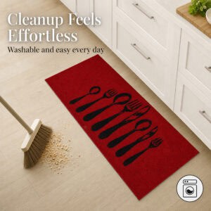 Red kitchen runner on a wood floor beside a broom sweeping crumbs, showing the washable surface that makes everyday cleanup feel effortless.