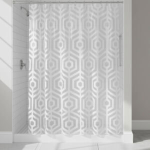 White hexagon-pattern shower curtain hanging in tiled shower
