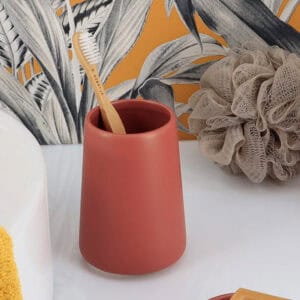Terracotta toothbrush holder with bamboo toothbrush in bathroom