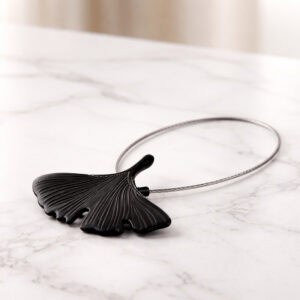 "Black metal ginkgo leaf curtain tieback with steel wire loop displayed on marble surface"