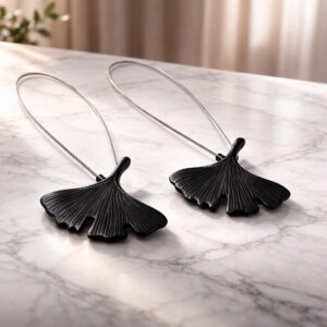 "Two black metal ginkgo leaf magnetic curtain tiebacks displayed on a marble surface"