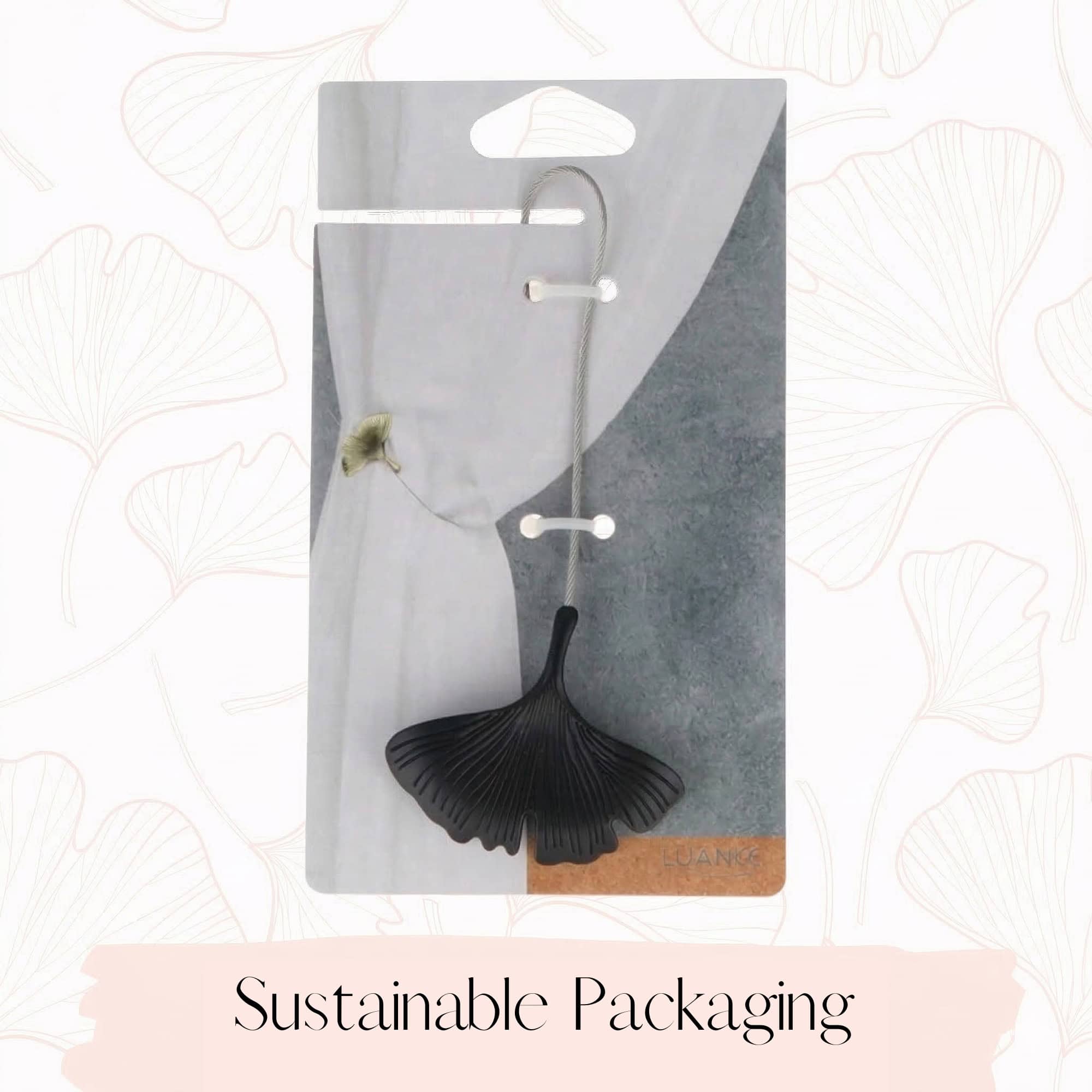 "Set of two black metal ginkgo leaf magnetic curtain tiebacks shown in sustainable retail packaging"