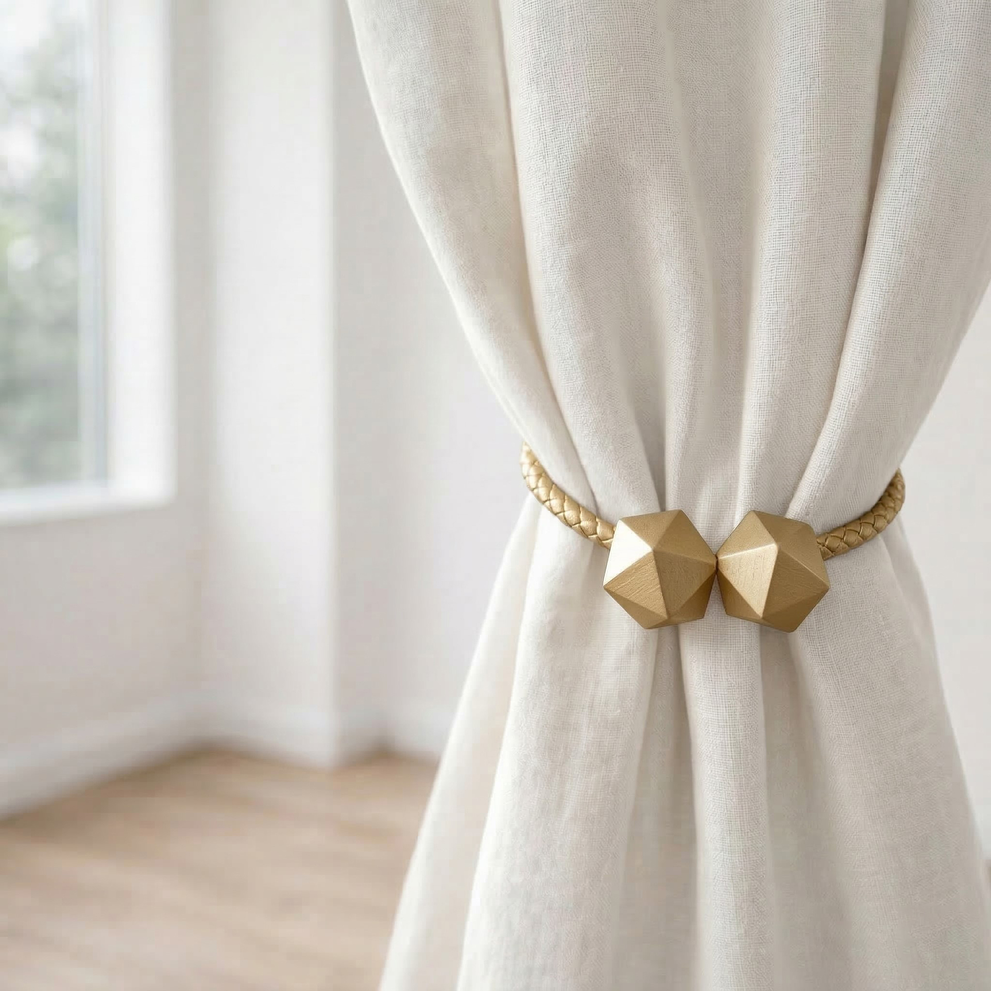 Gold geometric curtain tieback holding bundled ivory linen curtain