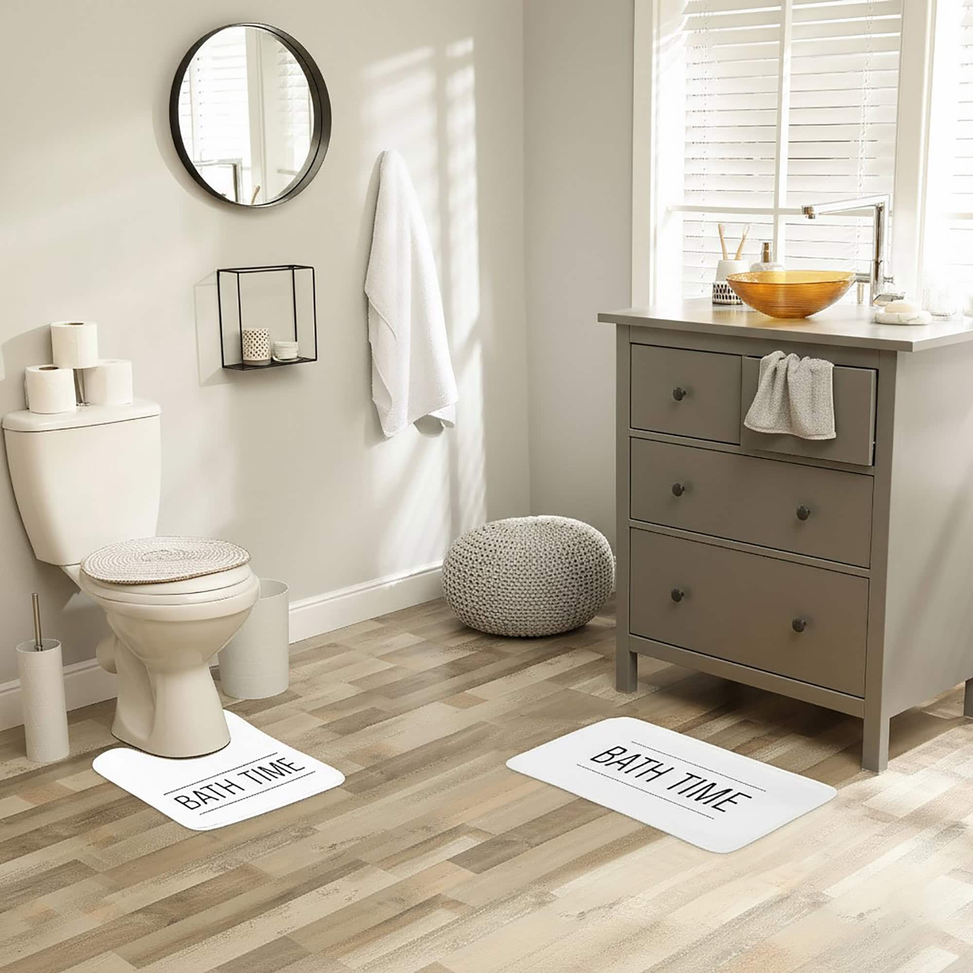 white and black bathmat set writing bath time on bathroom floor