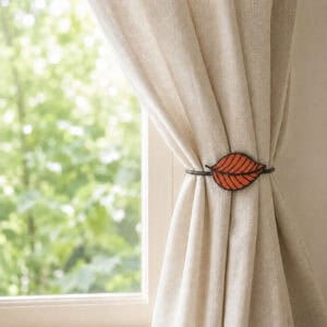 Terracotta leaf tieback holding a linen curtain back beside a sunny window